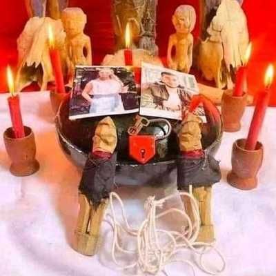 Altar de amarre de amor con figuras de madera, fotos de una pareja, velas rojas